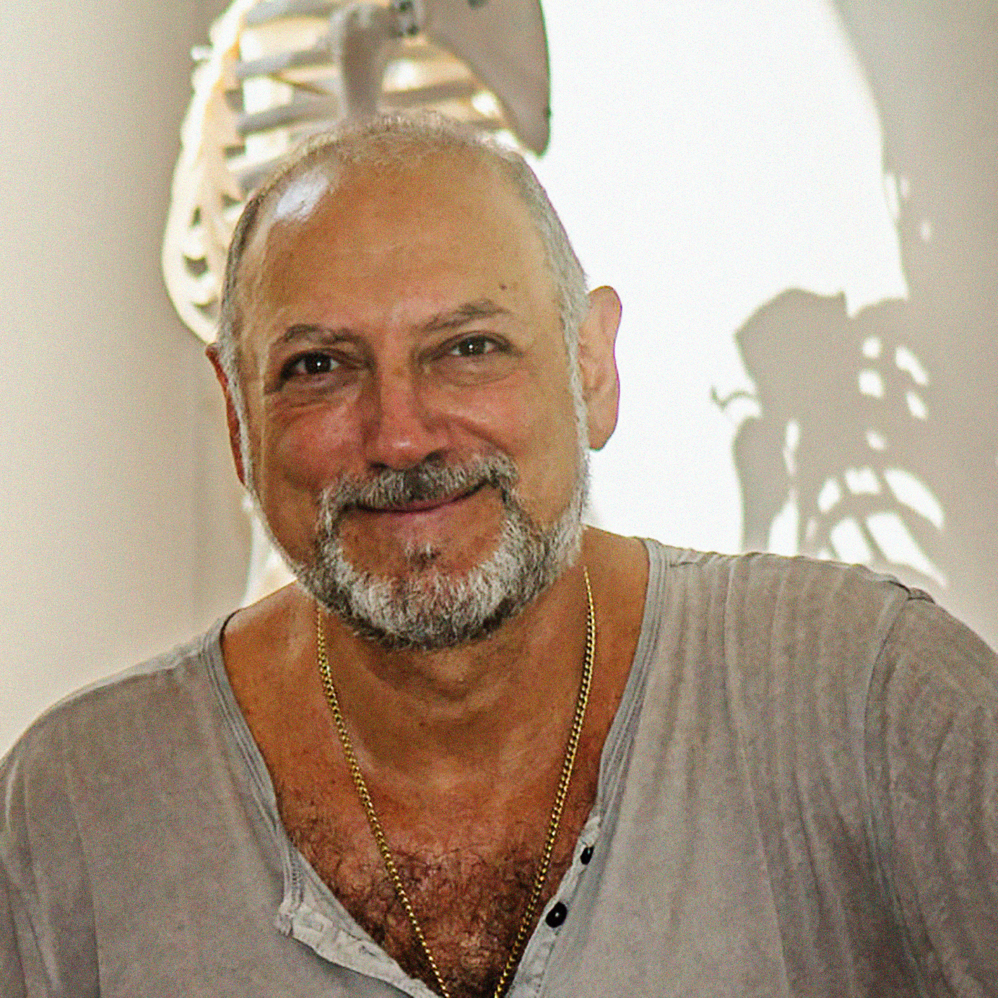 LAK_DSC2370-skeleton-shadow Leslie seated in from of skeleton casting shadow on wall behind him